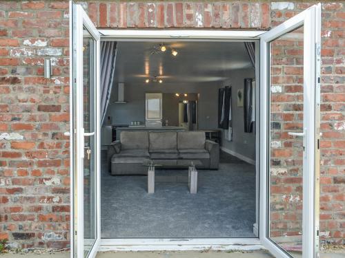 an open door into a living room with a couch at Dotterel Cottage - Uk39264 in Reighton