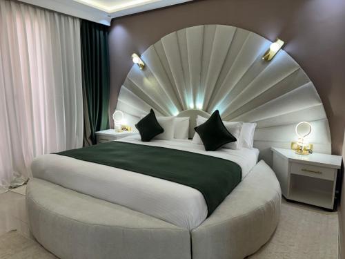 a bedroom with a large bed with a large headboard at RS Hôtel Karam Resort in Ouarzazate