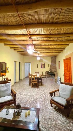 a living room with tables and chairs and a fireplace at By Lela in Tinogasta