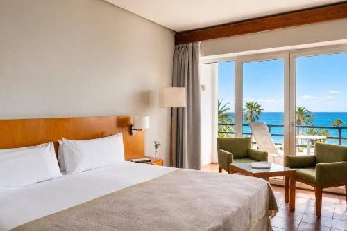 a bedroom with a bed and a view of the ocean at Parador de Ceuta in Ceuta