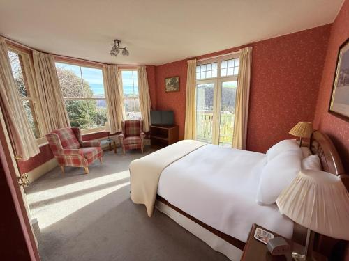 a bedroom with a large white bed and windows at Ingleside in Lynton