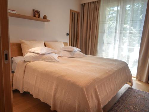a bedroom with a large bed with a window at Hotel Carmen in Eforie Nord