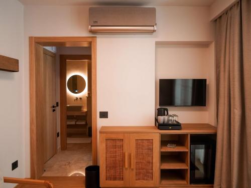 a room with a tv and a desk with a television at Hotel Carmen in Eforie Nord