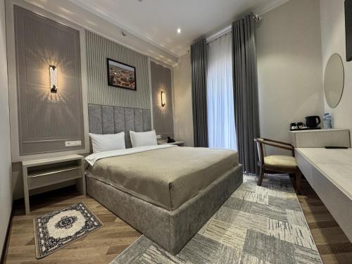 a hotel room with a bed and a desk at Karvon Plaza Hotel in Samarkand