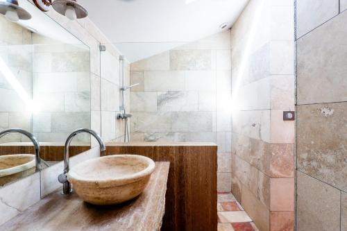 a bathroom with a large stone sink and a shower at La Grange D'anthounin in Redortiers