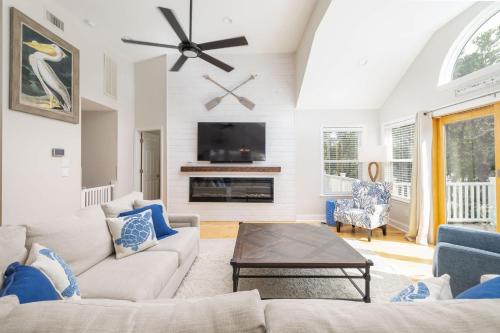 a living room with a couch and a tv at Oceanside retreat with pool & spa June Weeks Open in Sanderling