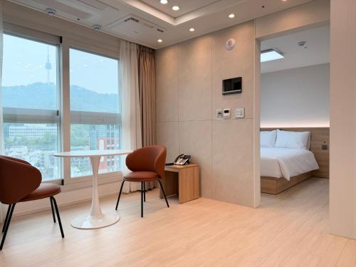 a hotel room with a bed and a table and chairs at TRAVELUS Myeongdong 트래블어스 명동 in Seoul