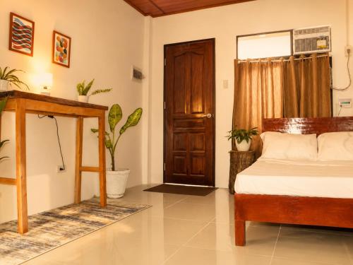 a bedroom with a bed and a wooden door at Pahuway - Comfort and style in Moalboal