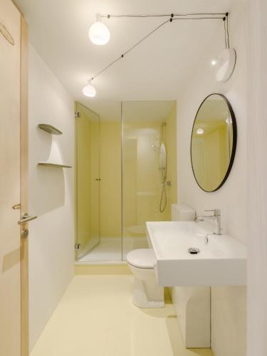 a bathroom with a sink and a toilet and a mirror at Haus des Onkels in Hittisau