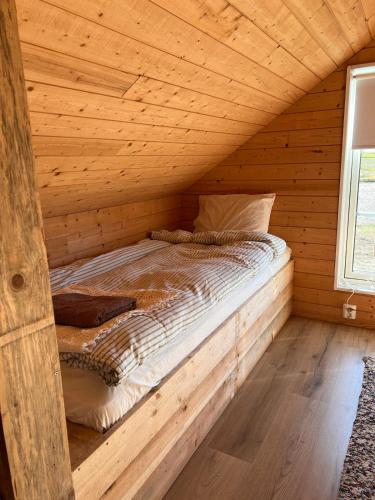 a bed in a wooden room in a log cabin at Bergsbo Lodge in Halmstad