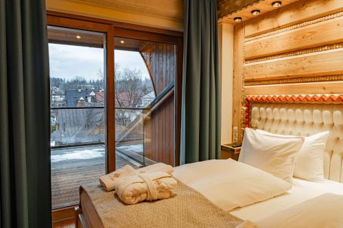 a bedroom with a bed and a large window at Mountain Diamond Resort in Zakopane