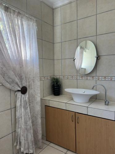 a bathroom with a sink and a mirror at Anja Guesthouse in Modimolle