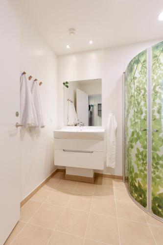 ein Badezimmer mit Waschbecken und Dusche in der Unterkunft Hotel Fårup in Blokhus