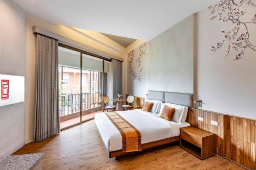 a bedroom with a large bed and a large window at Taladnoi 24 Hostel in Bangkok