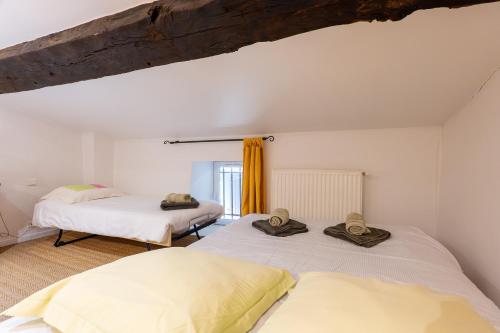 two beds in a room with white walls at Bastide de Marius in Redortiers