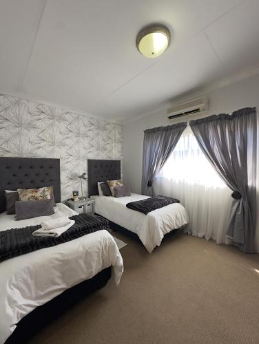 a bedroom with two beds and a window at Anja Guesthouse in Modimolle