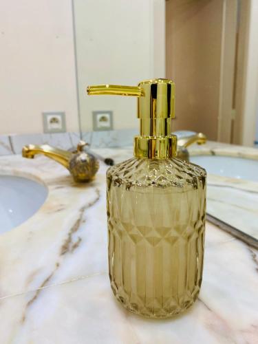 a gold soap dispenser sitting on a bathroom counter at L'escale vosgienne in Saint Die