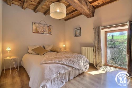 a bedroom with a bed and a large window at Le gué de brocéliande in Plélan-le-Grand