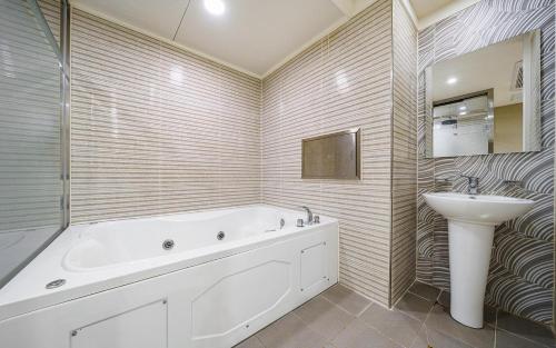 a bathroom with a tub and a sink at 자자호텔 in Goseong