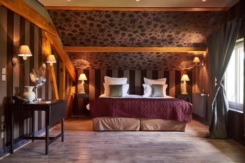 a bedroom with a bed and a table with lamps at Hôtel Le Manoir des Montagnes in Les Rousses