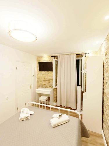 a bedroom with a bed with two towels on it at Fiore Kampielo Apartment in Corfu