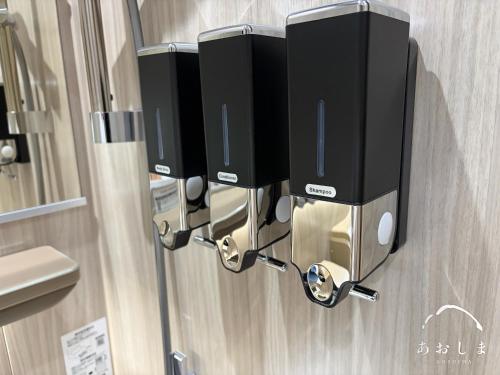a soap dispenser on the wall of a bathroom at Aoshima あおしま in Kameshima