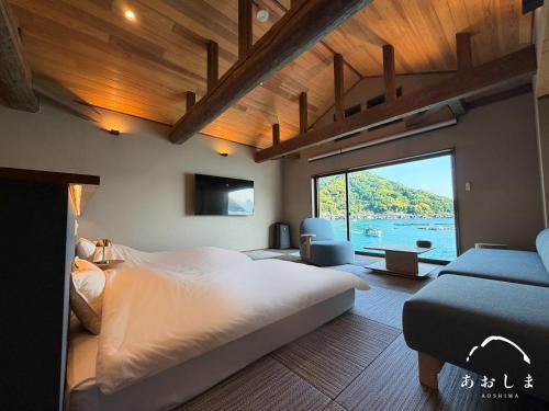 a bedroom with a large bed and a large window at Aoshima あおしま in Kameshima