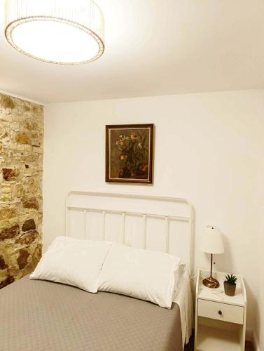 a bedroom with a bed and a painting on the wall at Fiore Kampielo Apartment in Corfu