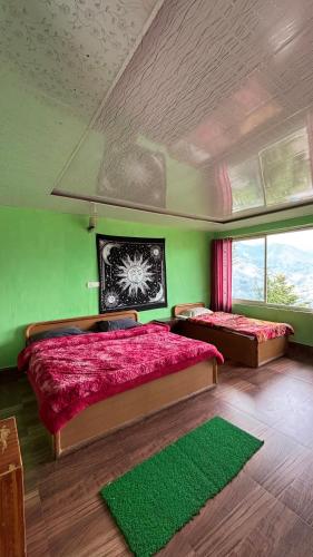 a bedroom with two beds and a green wall at Hotel Chandra Paradise in Munsyari
