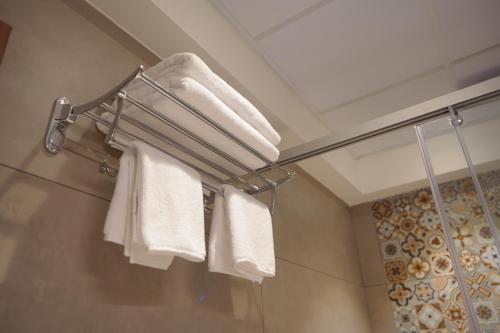 a bathroom with white towels on a towel rack at Hotel Jubilee Park- Kondapur in Hyderabad