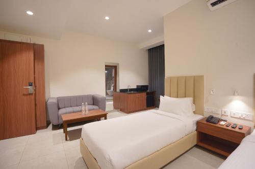 a hotel room with a bed and a couch at Hotel Jubilee Park- Kondapur in Hyderabad