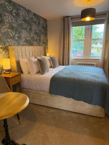 a bedroom with a bed and a window and a table at Little Fairfield in Ashover