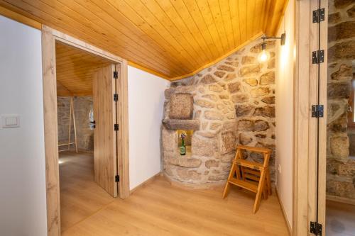 a room with a stone wall and a wooden ceiling at Casa Ti Nogueira in Soajo