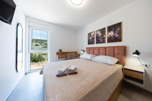 a bedroom with a bed with two shoes on it at Premium Šimuni by Pag tours in Šimuni
