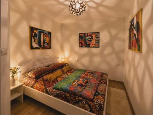a bedroom with a bed and some pictures on the wall at Artystyczny Picasso apartament z widokiem na jezioro i tarasem in Charzykowy
