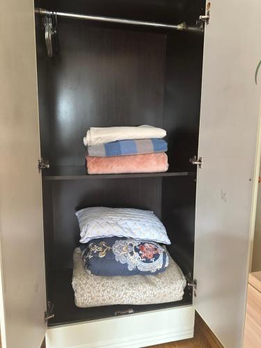 a closet with three pillows and towels in it at Cozy 2 BR Apartment with Easy Access in Ulaanbaatar