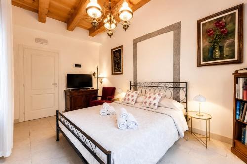 a bedroom with a bed and a chandelier at Aurisina residence in Aurisina
