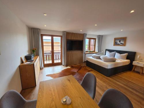 a hotel room with a bed and a table at Allgäuer Ferienwohnung mit Balkon, Bergblick und Wallbox in Rettenberg