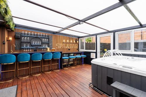 a bar with blue bar stools and a white tub at Riverside Villas in Manchester