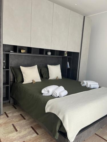 a bedroom with a large green bed with two white pillows at Vittorino house in Polignano a Mare