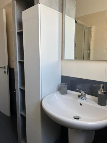 a bathroom with a white sink and a mirror at Vittorino house in Polignano a Mare