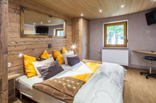 ein Schlafzimmer mit einem Bett mit gelben Kissen in der Unterkunft Gasthaus-Pension Reiterklause in Leutasch