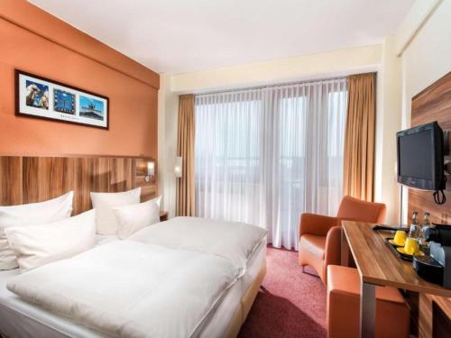 a hotel room with a large bed and a desk at Braunschweig Seminarius Hotel by Belvilla in Braunschweig