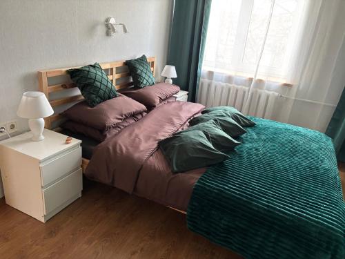 a bedroom with two beds with pillows and a window at Cimmele Apartment in Sigulda