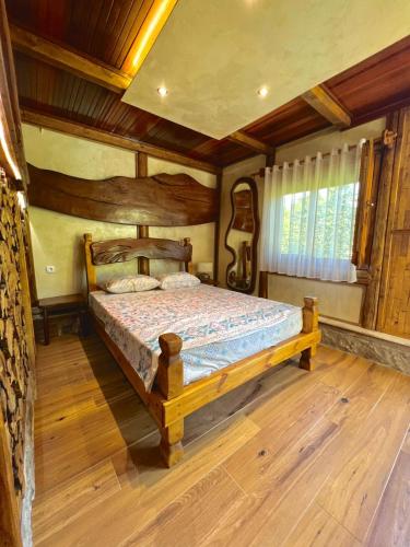 a bedroom with a wooden bed in a room at Forest Home 2 in Železnička Stanica )) (( Gornja Plavnica