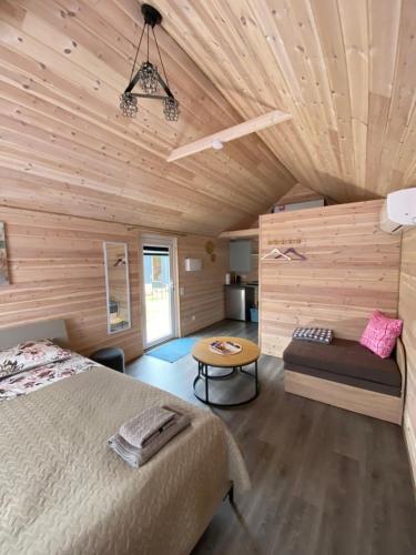 a bedroom with a bed and a wooden ceiling at Trijų namelių uostas in Dreverna