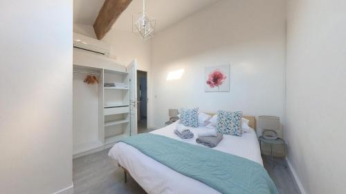 a bedroom with a large bed with blue pillows at Maison M Bed and Breakfast in Alignan-du-Vent