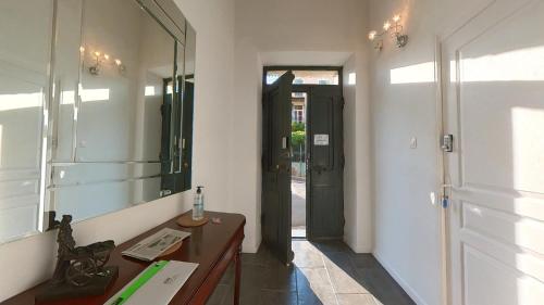 a bathroom with a sink and a mirror and a door at Maison M Bed and Breakfast in Alignan-du-Vent