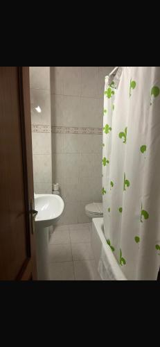 a bathroom with a sink and a shower curtain with leaves at hosteria de Boo in Boó de Piélagos