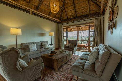 a living room with a couch and chairs and a table at Kidepo Wilderness Lodge in Loitanit